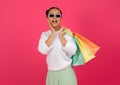 Surprised asian shopper lady in trendy sunglasses holding colorful shopping bags Royalty Free Stock Photo
