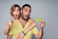 Surprised astonished couple showing blank credit card and pointing at you