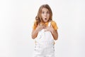 Surprised astonished cute little girl with blond hair blue eyes, touch chest ambushed, pouting fold lips say wow amazed Royalty Free Stock Photo