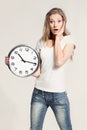 Surprised attractive young woman holding big clock Royalty Free Stock Photo