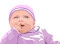 Surprised baby with blue eyes dressed in pink clothes. Holding finger in mouth