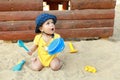 Surprised baby boy playing in sand with scoop in sandbox Royalty Free Stock Photo