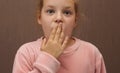 Surprised kid girl closed her mouth Royalty Free Stock Photo