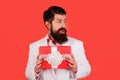 Surprised bearded man with gift box. Businessman with present on Womens or mothers Day, birthday. Handsome male with Royalty Free Stock Photo