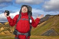 Surprised by the beauty of nature tourist man in a red jacket with binoculars in his hands on a background of mountainous terrain Royalty Free Stock Photo