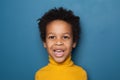 Surprised black kid boy on blue background