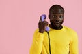 Surprised black man talking on retro phone portrait