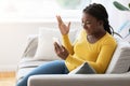 Surprised Black Woman Making Video Call On Smartphone At Home, Emotionally Gesturing Royalty Free Stock Photo