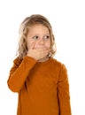 Surprised blond child with blue eyes covering his mouth Royalty Free Stock Photo