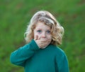 Surprised blond child covering his mouth Royalty Free Stock Photo