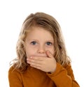 Surprised blond child with blue eyes covering his mouth Royalty Free Stock Photo