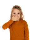 Surprised blond child with blue eyes covering his mouth Royalty Free Stock Photo