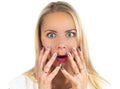Surprised blond girl with blue eyes screams and closes mouth with her hands from surprise. Presenting your product. Isolated Royalty Free Stock Photo