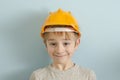 Surprised boy in the helmet of the builder. Blue background