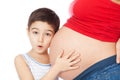 Surprised boy holding mother belly and listening Royalty Free Stock Photo