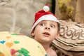 Surprised boy in santa hat in bed. New Year, Christmas expectation of a miracle, a surprise Royalty Free Stock Photo