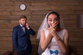 Surprised bride against groom talking on the phone Royalty Free Stock Photo