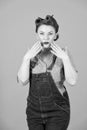 Surprised brunette woman with hands to face. Denim american girl confused on grey background. Pin-up styled brunette woman with