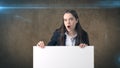 Surprised Business woman portrait with blank white board on brown isolated . Female model with long hair. Royalty Free Stock Photo