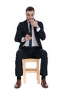 Surprised businessman holding phone and gasping, covering his mouth