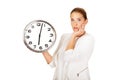 Surprised businesswoman holding a big clock