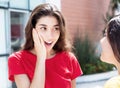 Surprised caucasian girl speaking with girlfriend