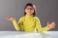 Surprised cheerful child with eyeglasses enjoying thrilled hand gesture