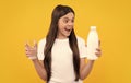 surprised child hold dairy beverage product. teen girl going to drink milk.