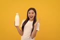 surprised child hold dairy beverage product. teen girl going to drink milk.