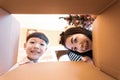 The surprised child and mom unpacking, opening the carton box and looking inside. Unboxing inside view, asian family Royalty Free Stock Photo