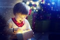 Surprised child opening and looking inside a magic gift