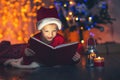 Surprised child opening magic Christmas book.