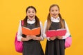 Surprised children in formal uniforms read school books yellow background, library Royalty Free Stock Photo