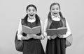 Surprised children in formal uniforms read school books yellow background, library Royalty Free Stock Photo
