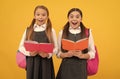 Surprised children in formal uniforms read school books yellow background, library Royalty Free Stock Photo