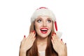 Surprised Christmas woman in Santa hat and red manicured nails isolated on white background. Christmas and New Year portrait Royalty Free Stock Photo