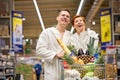 Surprised couple family emotionally react on discounts in grocery store, in bathrobe Royalty Free Stock Photo