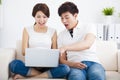 Surprised Couple on sofa with laptop