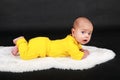 Surprised and curious baby boy lying on white fur