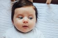 Surprised cute baby with blues eyes close portrait, lying in bed Royalty Free Stock Photo