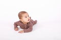 Surprised baby boy in brown clothes crawling on white Royalty Free Stock Photo