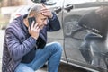 A surprised driver calls the insurance company or the police because an unknown culprit has damaged his car