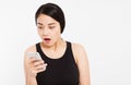 Surprised emotional asian female hold phone and isolated on white background