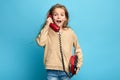 Surprised emotionl excited girl talking with red phone