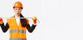 Surprised and excited asian female construction engineer, industrial worker in safety helmet and uniform, measuring Royalty Free Stock Photo