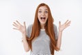 Surprised excited redhead emotive enthusiastic redhead young girl screaming thrilled raising hands widen eyes impressed