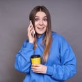 A surprised female in a blue hoodie is talking on the phone Royalty Free Stock Photo