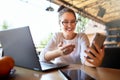 Surprised freelancer mixed race woman looks at smartphone and can not believe she won lottery prize. Successfull amazed Royalty Free Stock Photo