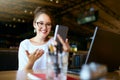 Surprised freelancer mixed race woman looks at smartphone and can not believe she won lottery prize. Successfull amazed Royalty Free Stock Photo