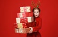 Surprised funny child girl in red Christmas reindeer costume with gifts on green   background Royalty Free Stock Photo